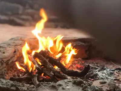 a fire in a rock with flames in it at Wadi Rum Paris Cave in Wadi Rum