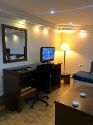 a room with a desk with a computer and a couch at Petra EcoStay in Wadi Musa