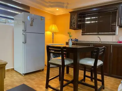 a kitchen with a table and a white refrigerator at Petra EcoStay in Wadi Musa