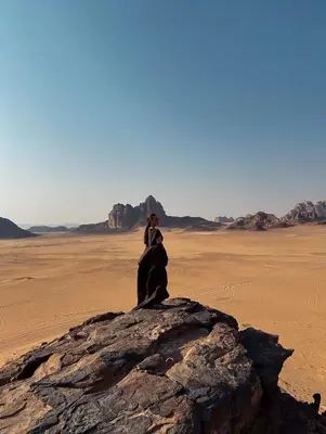 a couple standing on a rock in the desert at RUM DESERT BREEZE lUXURY CAMP&JEEP TOUR in Wadi Rum
