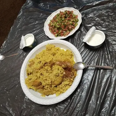 a table with two plates of scrambled eggs and a salad at بيت راس هوستل in Bayt Raʼs
