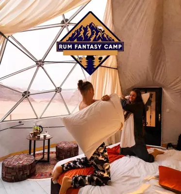 two people are making beds in a tent at RUM FANTAS BUBBLE lUXURY CAMP in Wadi Rum