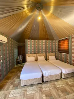 two beds in a room with a ceiling at Lowrance luxury camp in Wadi Rum