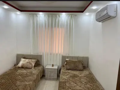 a bedroom with two beds and a television in it at شقه مفروشة ذات اطلالة جميلة ومكان هادئ in Irbid