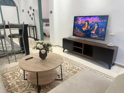 a living room with a flat screen tv and a table at Old Town Charming Two-Bedroom Flat in Amman