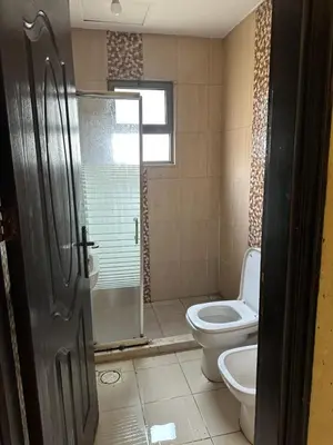 a bathroom with a toilet and a glass shower door at شقه مفروشه in Amman