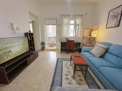 a living room with a blue couch and a tv at 2 Bedroom apt in Jabal Weibdeh with Balcony in Amman