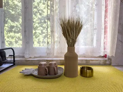 a table with two mugs and a vase with grass at 2 Bedroom apt in Jabal Weibdeh with Balcony in Amman