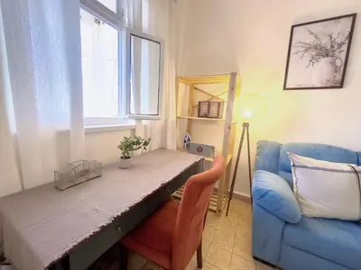 a living room with a table and a blue couch at 2 Bedroom apt in Jabal Weibdeh with Balcony in Amman