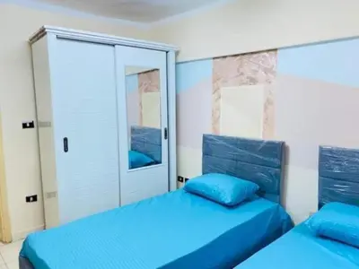 a bedroom with two blue beds and a closet at اذرح فارم in Udhruḩ