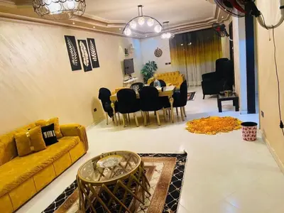 a living room with a yellow couch and a dining room at ساكب هاوس in Sākib