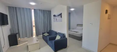 a living room with a blue chair and a bed at مراسيم للشقق الفندقية in Amman