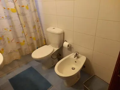 a bathroom with a toilet and a bidet at Happy Family Home with Spacious Garden in Amman