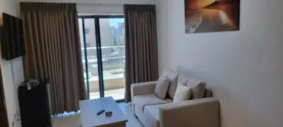 a living room with a white couch and a window at العبد للشقق الفندقية in Amman