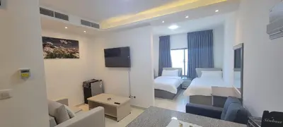 a hotel room with two beds and a couch at العبد للشقق الفندقية in Amman
