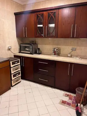 a kitchen with wooden cabinets and a microwave at الجفر موتل in Al Jafr