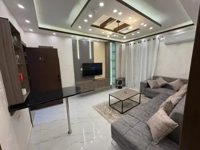 a living room with a couch and a tv at Third circle Luxury Hotel apartment New in Amman