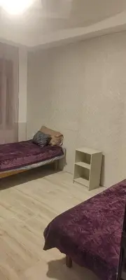a room with two beds and a small table at شقة مفروشة للايجار دوار المشاغل شارع الأقصى in Amman