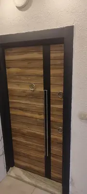 a wooden door in a room with a wall at شقة مفروشة للايجار دوار المشاغل شارع الأقصى in Amman