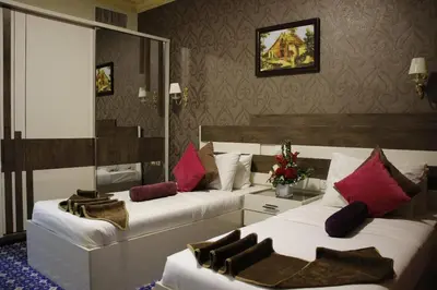 a hotel room with two beds with red pillows at Balcony Hotel in Amman