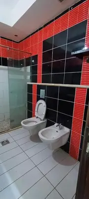 a bathroom with two toilets and a sink at الرمثا هوتل in Ar Ramthā
