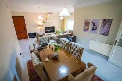 a living room with a wooden table and chairs at 3 Bedrooms Cozy Apartment Prime Location Walk Anywhere شقة مفروشة واسعة شارع الجاردنز in Amman