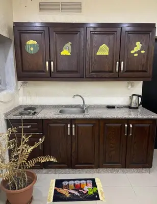 a kitchen with wooden cabinets and a sink at Falcon Real Estate in Amman