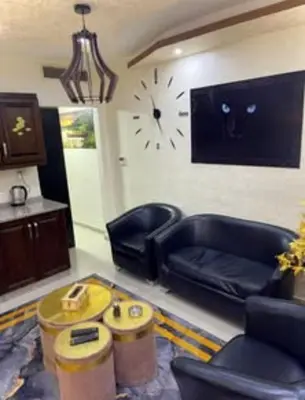 a living room with a couch and a clock on the wall at Falcon Real Estate in Amman