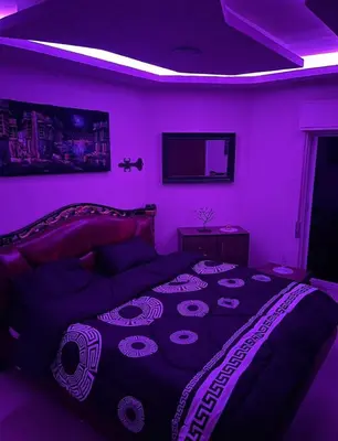 a purple room with a bed and a tv at Falcon Real Estate in Amman