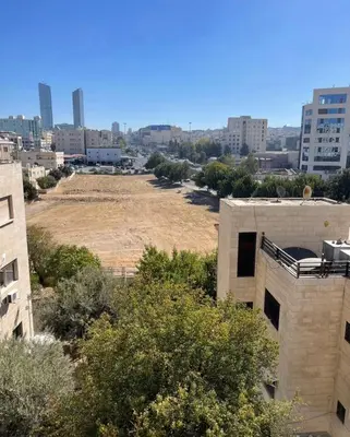 an empty field in the middle of a city at Falcon Real Estate in Amman