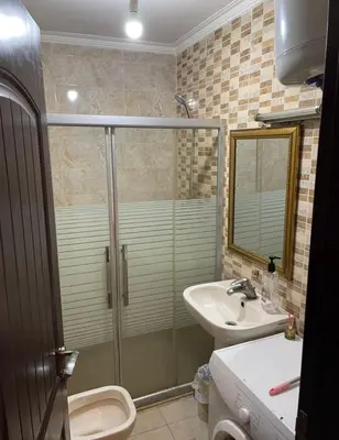a bathroom with a shower and a toilet and a sink at Falcon Real Estate in Amman
