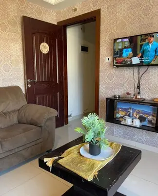 a living room with a couch and a table at Falcon Real Estate in Amman