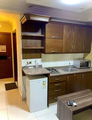 a kitchen with wooden cabinets and a white refrigerator at Falcon Real Estate in Amman