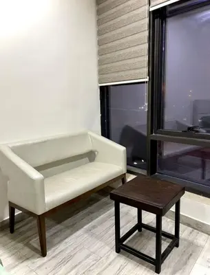 a living room with a white chair and a table at Falcon Real Estate in Amman