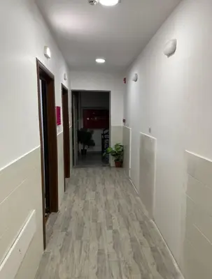 an empty hallway with white walls and wooden floors at Falcon Real Estate in Amman