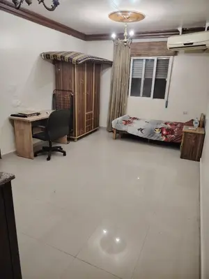a room with a desk and a bed and a desk and a chair at غرفة مفروشة in Irbid