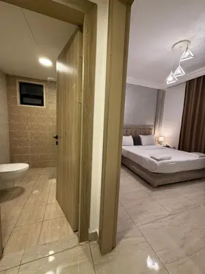 a bedroom with a bed and a bathroom with a toilet at unique 2bedroom at abdoun 007 in Amman