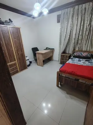 a bedroom with a bed and a desk in it at شقة مفروشة مدخل مستقل in Jurf ad Darāwīsh
