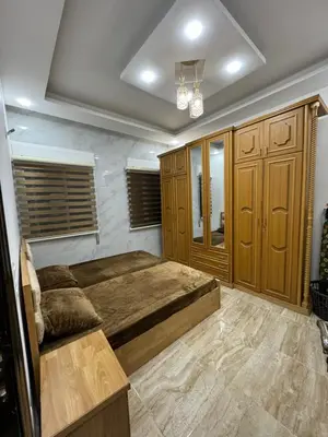 a bedroom with a large bed and wooden cabinets at Seventh circle stay - Cozy &Chic in Amman
