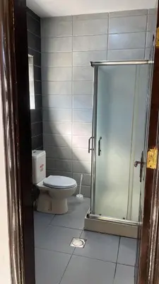 a bathroom with a toilet and a glass shower at Izz AlDin Tamimi St, Deluxe Jubaiha Furnished Apartment,3rd Edition in Amman