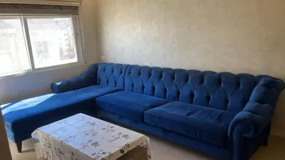 a blue velvet couch in a living room at Izz AlDin Tamimi St, Deluxe Jubaiha Furnished Apartment,3rd Edition in Amman