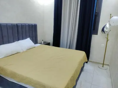 a bedroom with a bed with a gray headboard at Furnished apartments for rent 1 in Aqaba