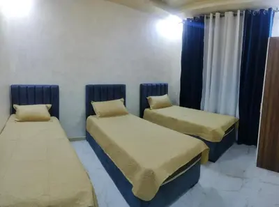 two beds in a room with blue curtains at Furnished apartments for rent 1 in Aqaba