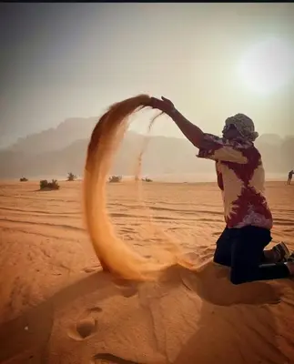 a person in the desert playing with a fire hose at Rum gate camp Fares in Disah