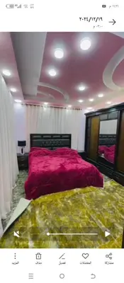 a bedroom with a large bed with a pink blanket at فيلا الاحلام in Irbid