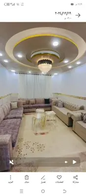 a living room with couches and a chandelier at فيلا الاحلام in Irbid