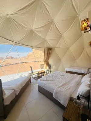 a bedroom with two beds and a view of the desert at Wadi Rum Salman camp in Wadi Rum