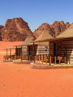 a building in the desert with mountains in the background at Ayla Rum Luxury Camp in Wadi Rum