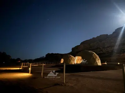 a group of tents in the desert at night at Wadi Rum ZAAD luxury Camp in Wadi Rum