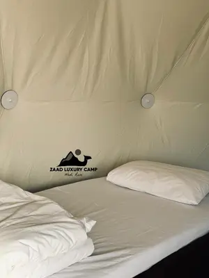 a bed in a tent with a sign on it at Wadi Rum ZAAD luxury Camp in Wadi Rum